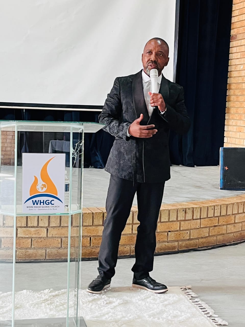 The senior pastor preaching at the transparent podium during a service